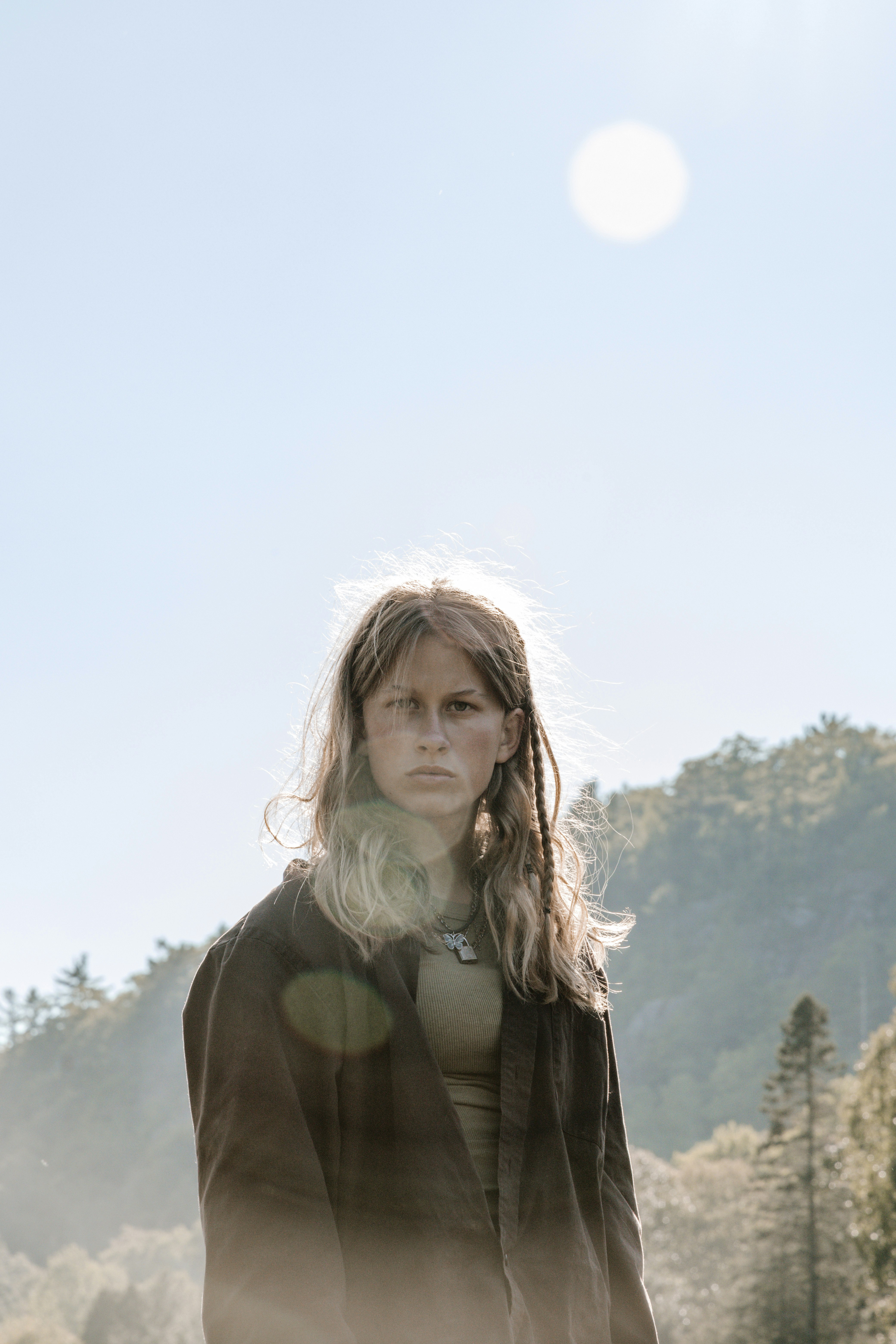 woman in green turtleneck sweater standing on green grass field during daytime